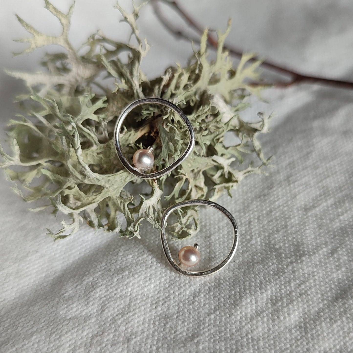 A pair of handcrafted silver earrings with pearls