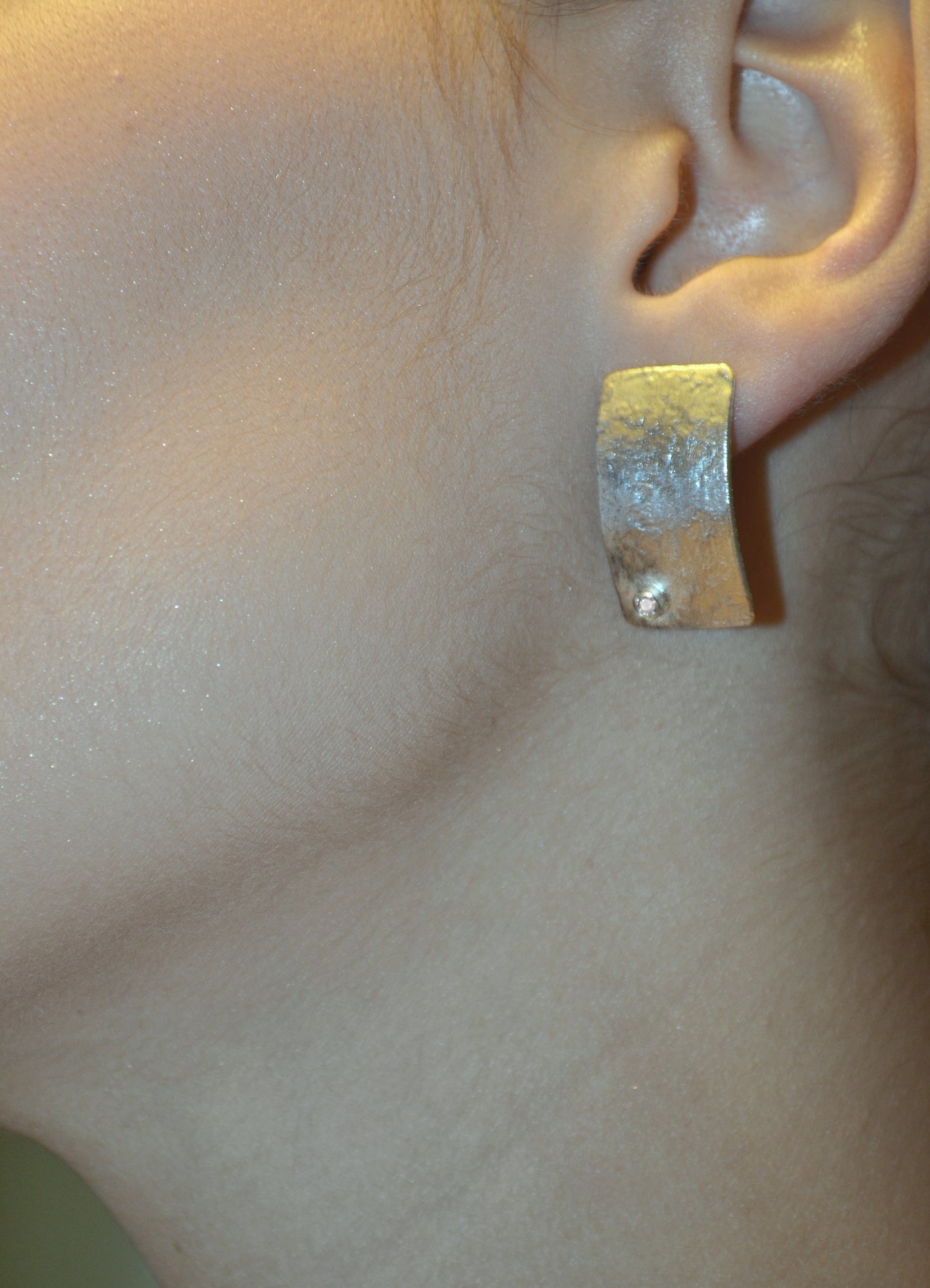 Model wearing rectangula silver earrings with zircon
