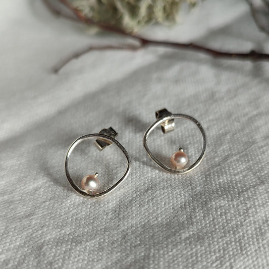 A pair of silver earrings with pearls