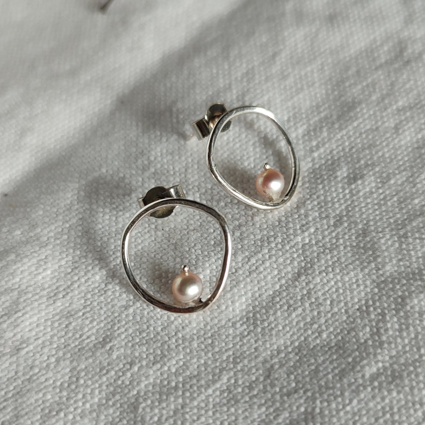 A pair of handcrafted silver earrings with pearls