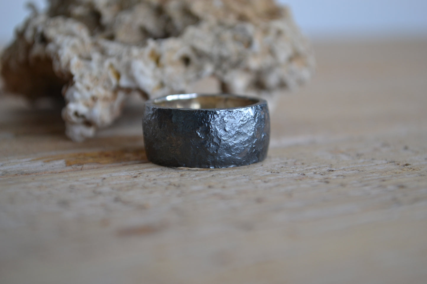 Man's wide ring of oxidated silver with irregular surface