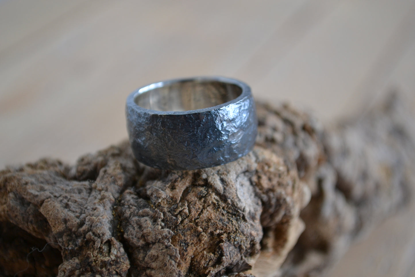 Man's wide ring of oxidated silver with irregular surface