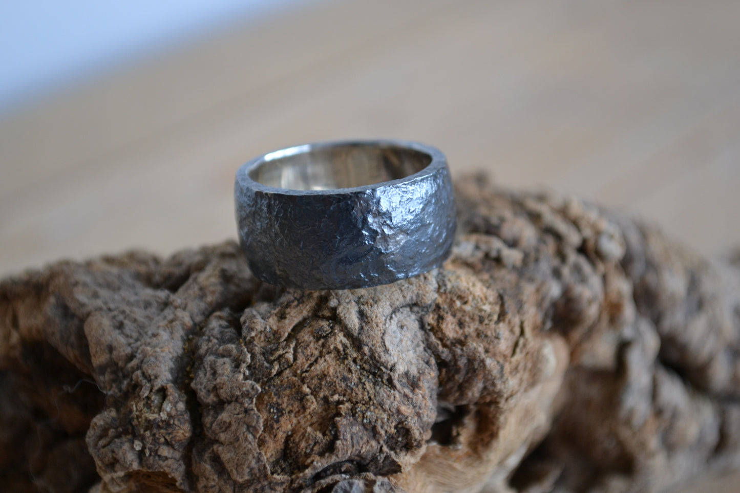 Man's wide ring of oxidated silver with irregular surface