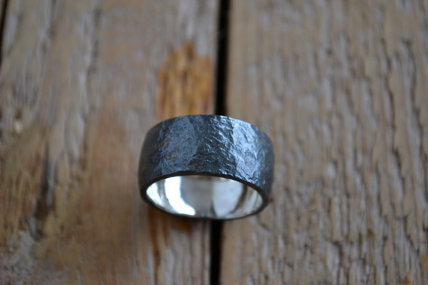 Man's wide ring of oxidated silver with irregular surface