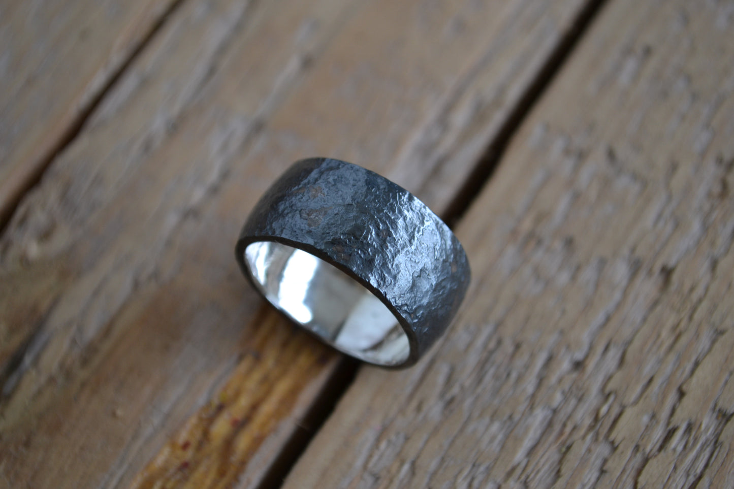 Man's wide ring of oxidated silver with irregular surface