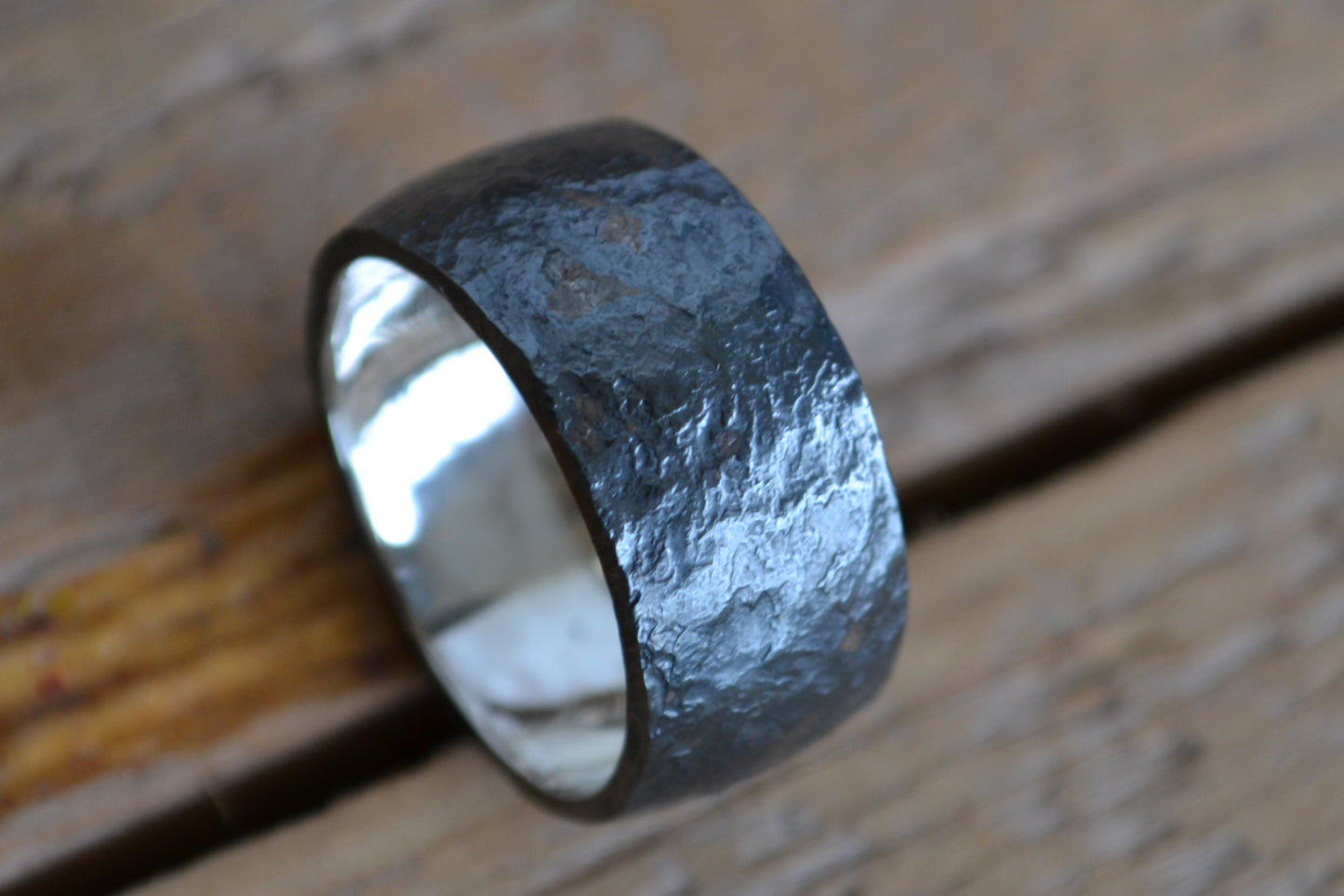 Man's wide ring of oxidated silver with irregular surface