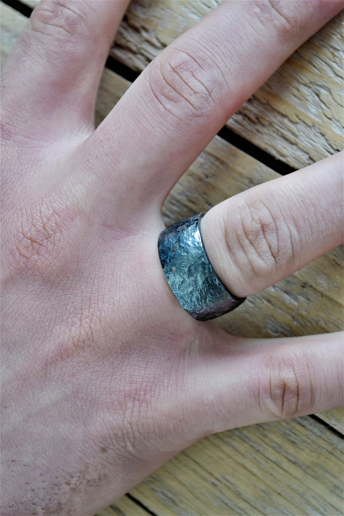 Man's wide ring of oxidated silver with irregular surface